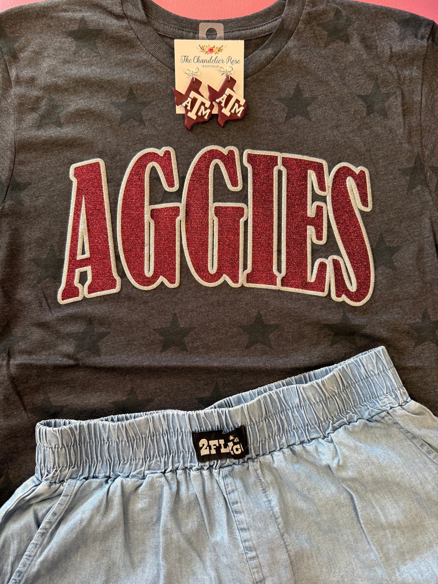 ARCHED AGGIES SMOKE STARS GAME DAY CHARCOAL BLACK TEE - MAROON/SILVER GLITTER PUFF
